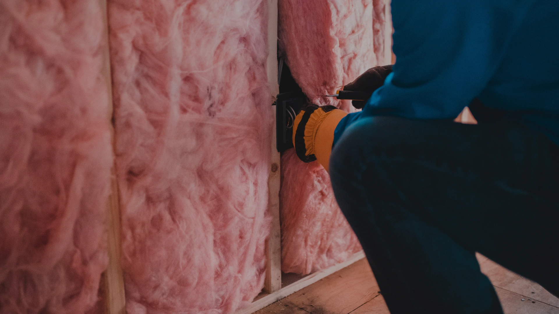 worker removing fiber glass of a wall